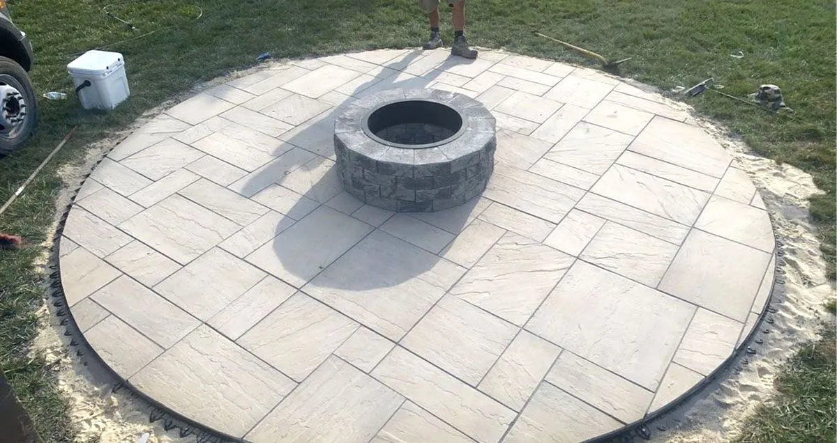 A fire pit is sitting in the middle of a circular patio
