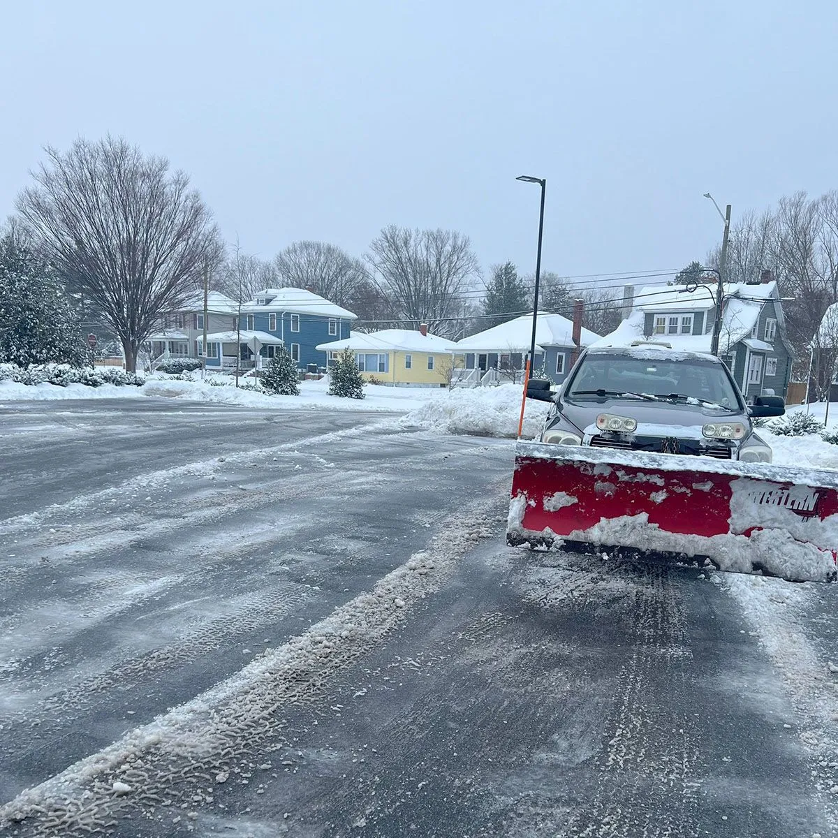 A snow plow is clearing snow from the road