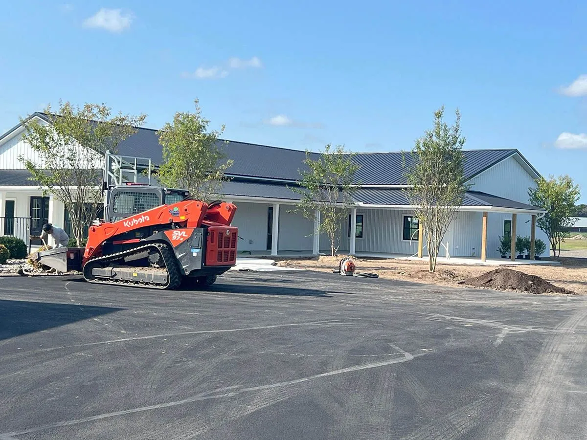 A heavy equipment vehicle is parked in front of a house